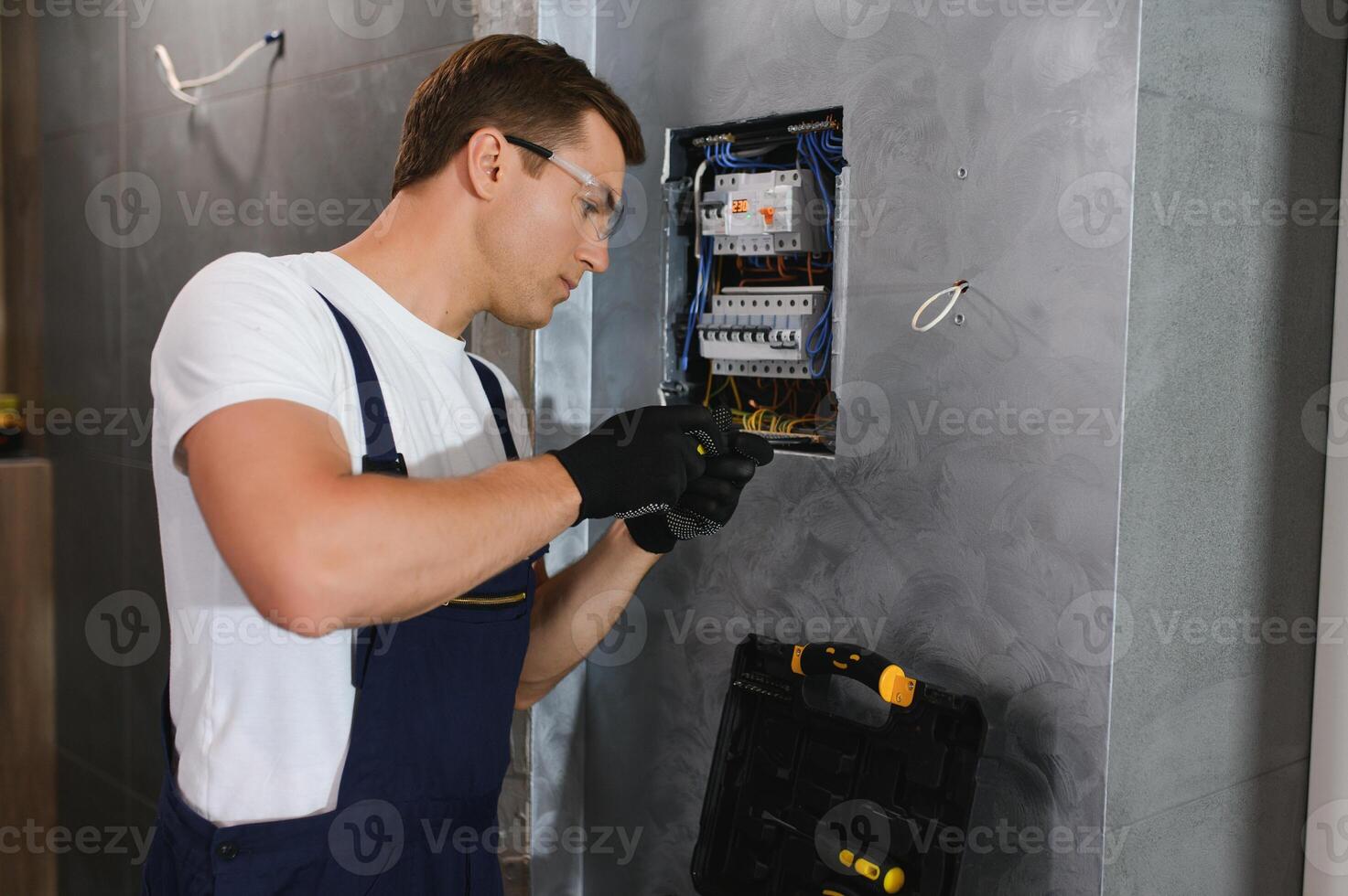 Electrician worker at work on an electrical panel photo