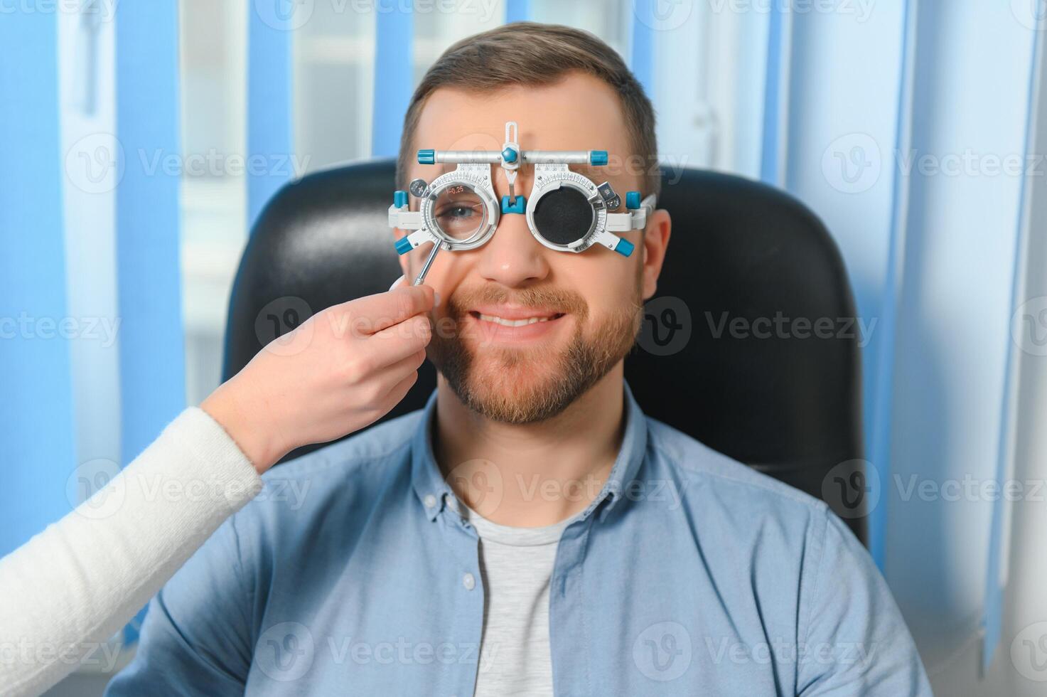 Handsome young man is checking the eye vision in modern ophthalmology clinic. Patient in ophthalmology clinic photo