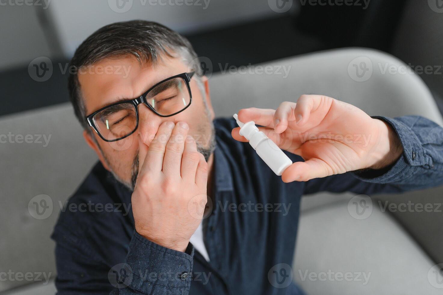 Sick man with nasal spray at home. photo