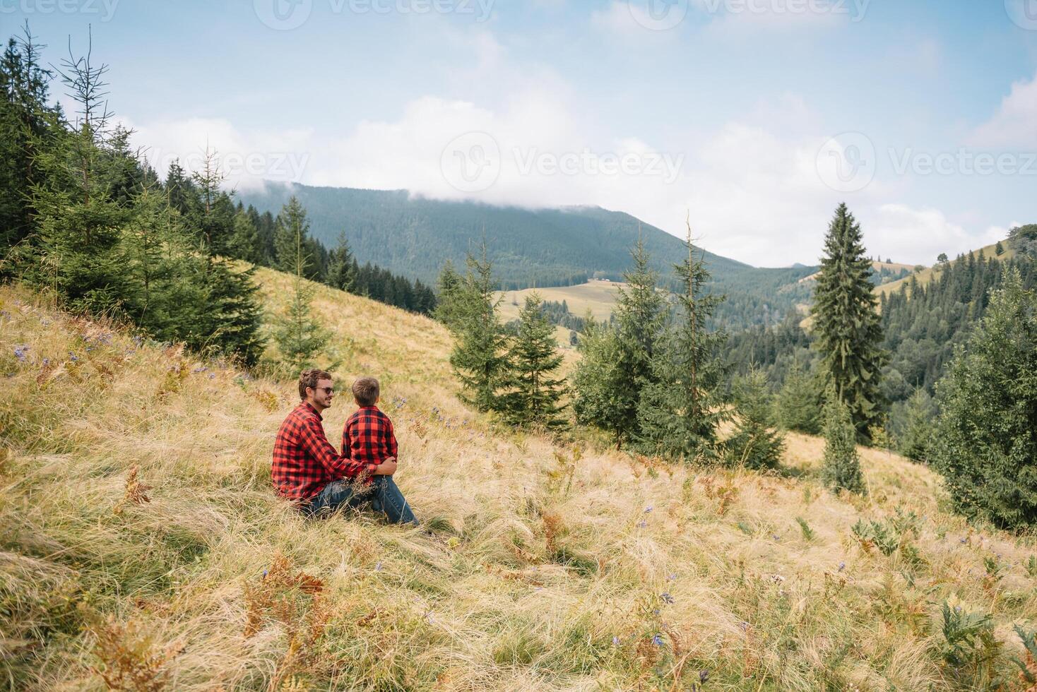 padre y niño excursionismo en escénico montañas. papá y hijo disfrutando el ver desde el montaña parte superior en cárpato montañas foto