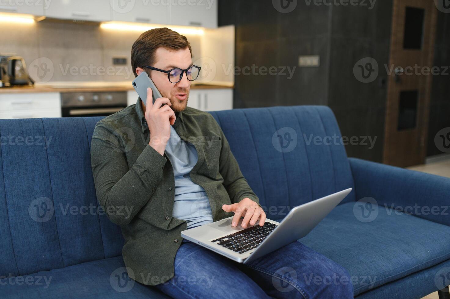 hombres trabajando en ordenador portátil computadora en su habitación. hogar trabajo o estudiar, Lanza libre concepto. joven hombre sentado relajado en sofá con ordenador portátil. moderno empresario utilizando ordenador portátil. foto