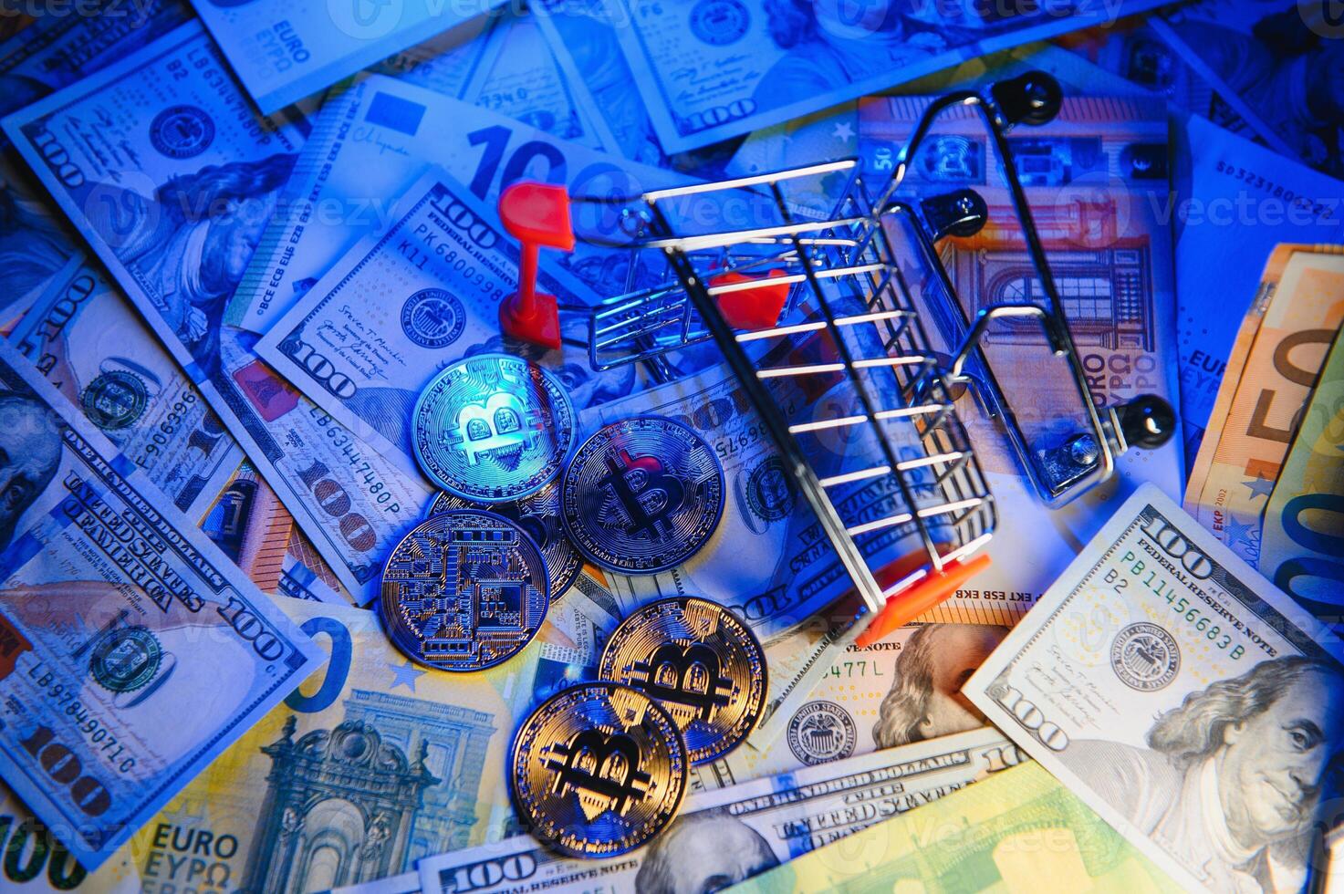 Close up heap of golden bitcoin physical coins on top of Euro, dollar banknotes background, high angle view, selective focus photo