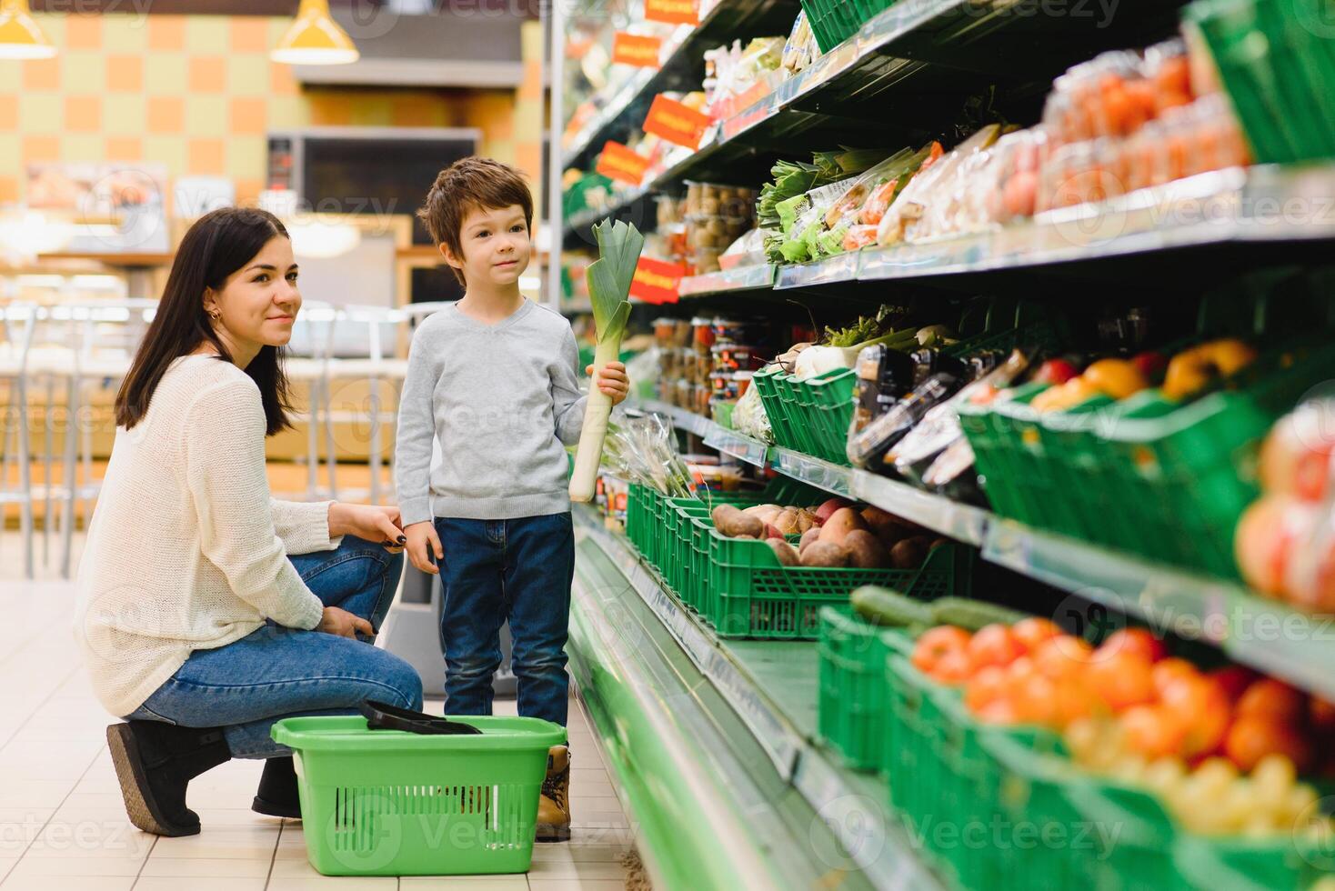 woman and child boy during family shopping with trolley at supermarket photo