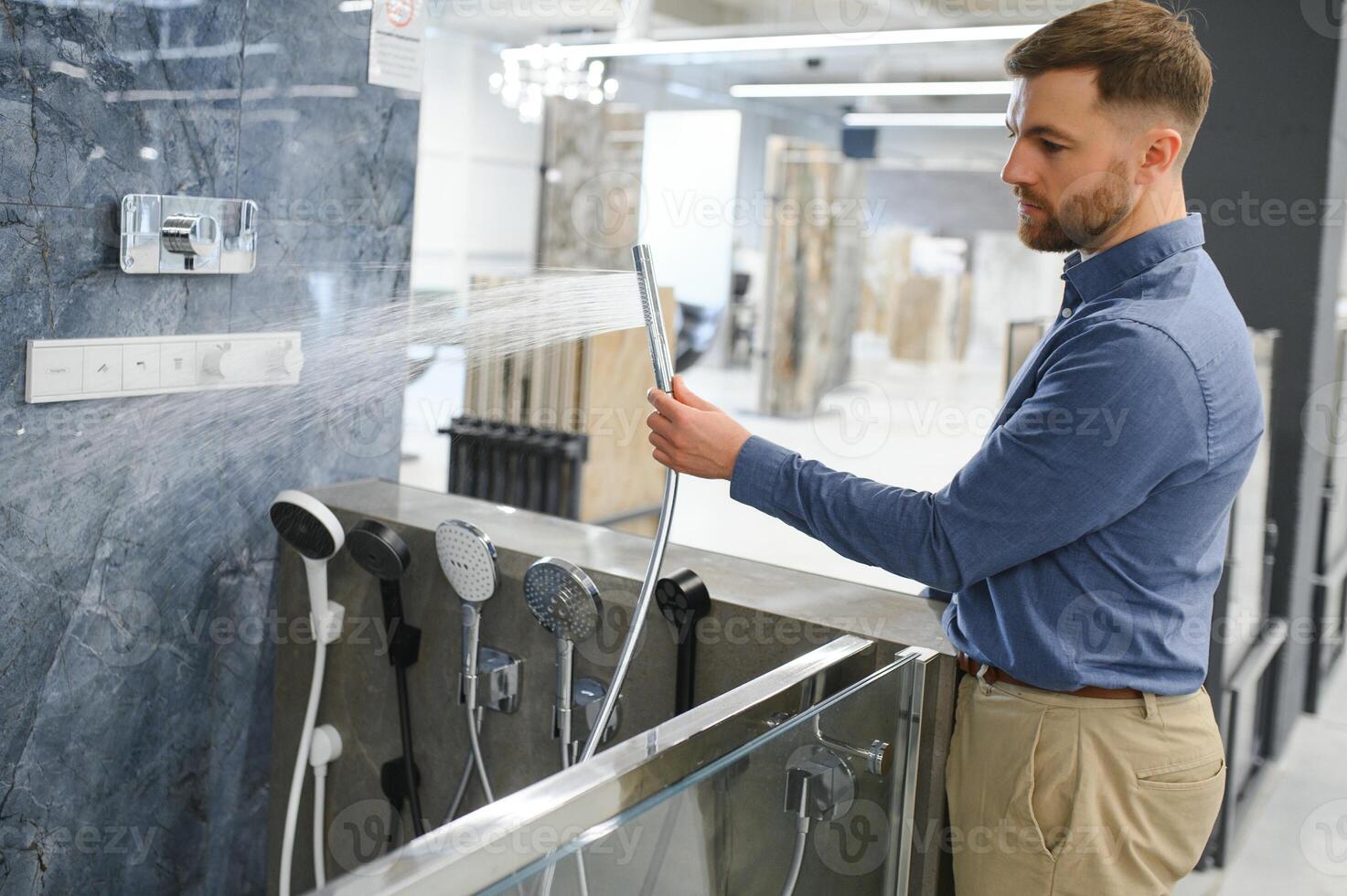Selects a shower faucet. Man chooses a products in a sanitary ware store photo