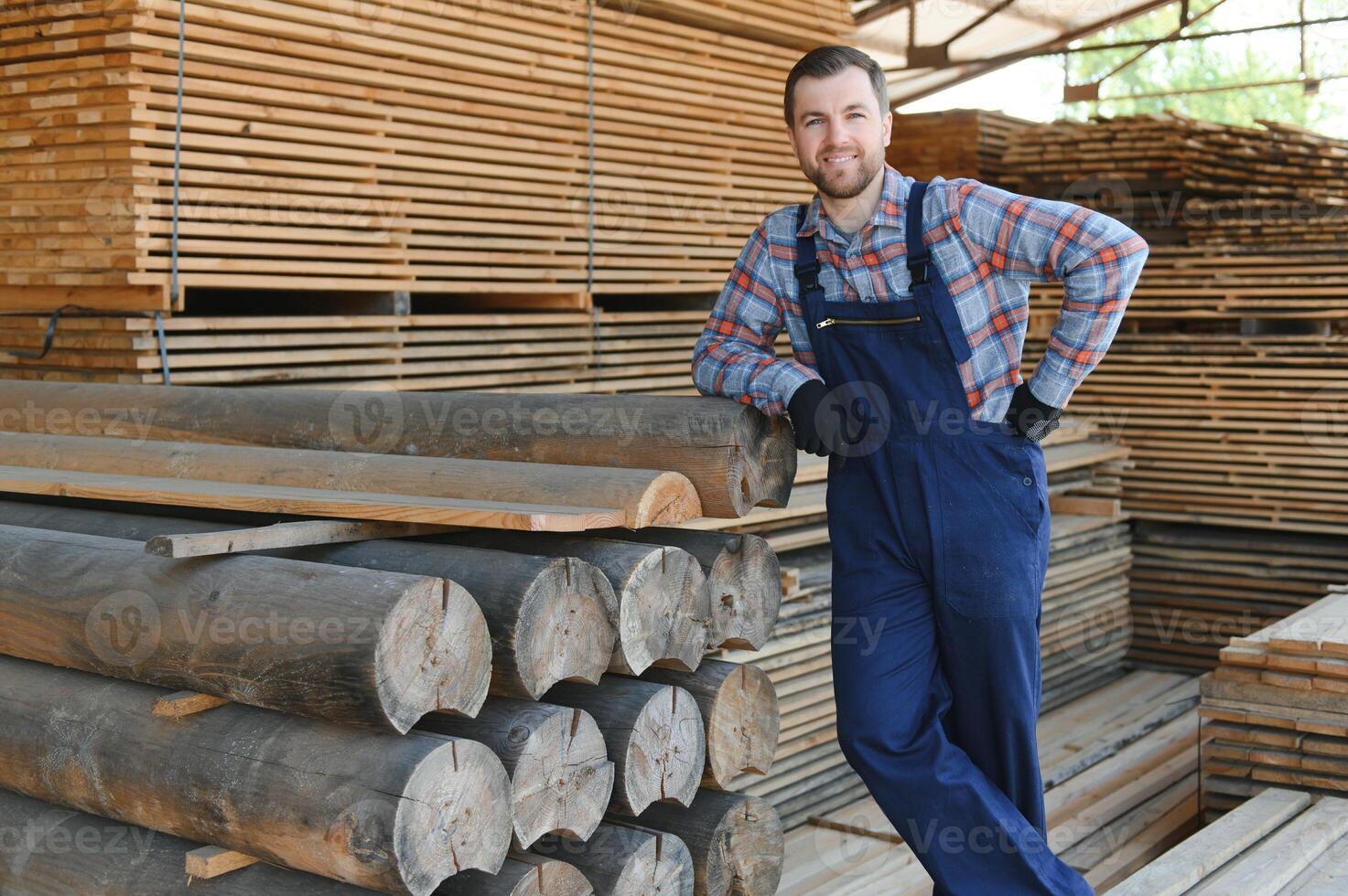 Carpenter in uniform check boards on sawmill photo