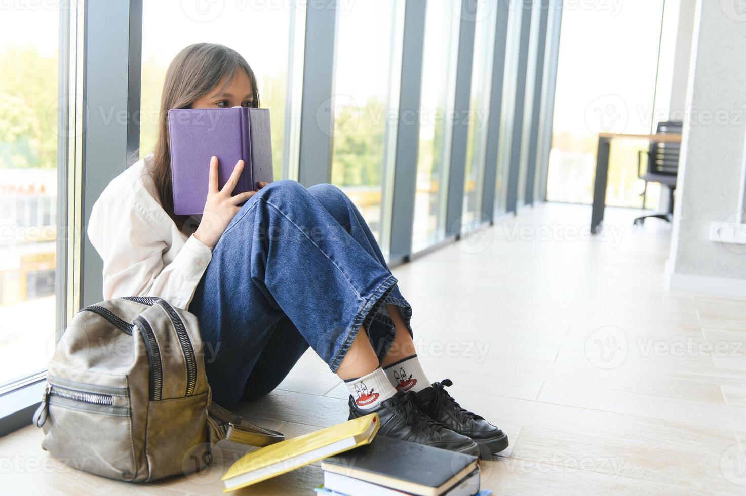 Lonely sad schoolgirl while all her classmates ignored her. Social exclusion problem. Bullying at school concept. photo