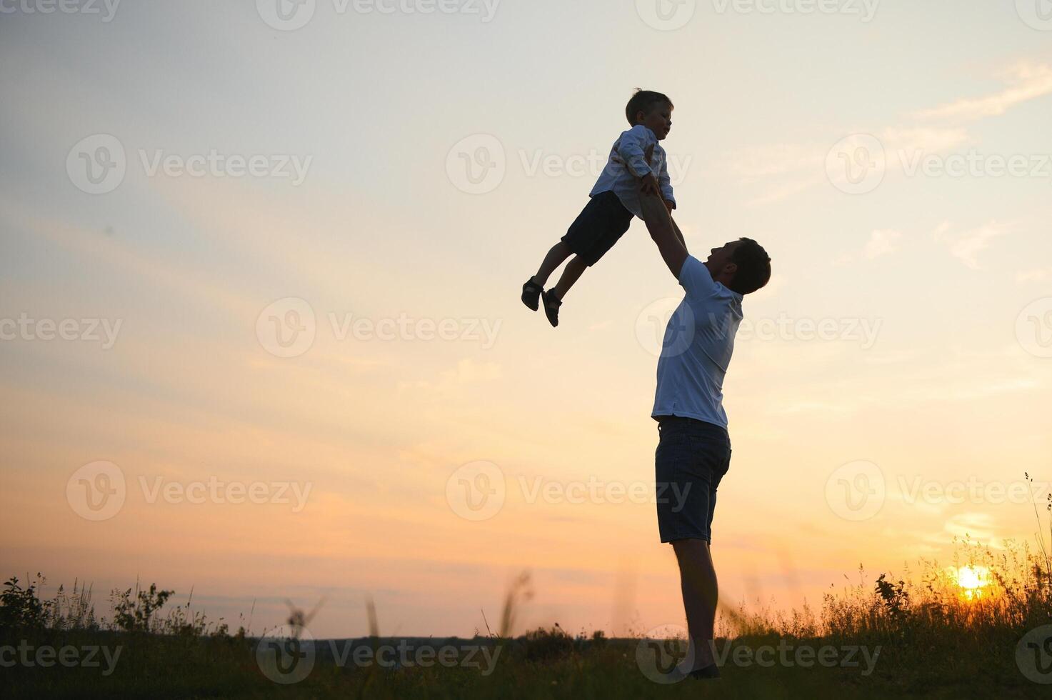 Happy father playing with son on sunset background .The concept of father's day photo