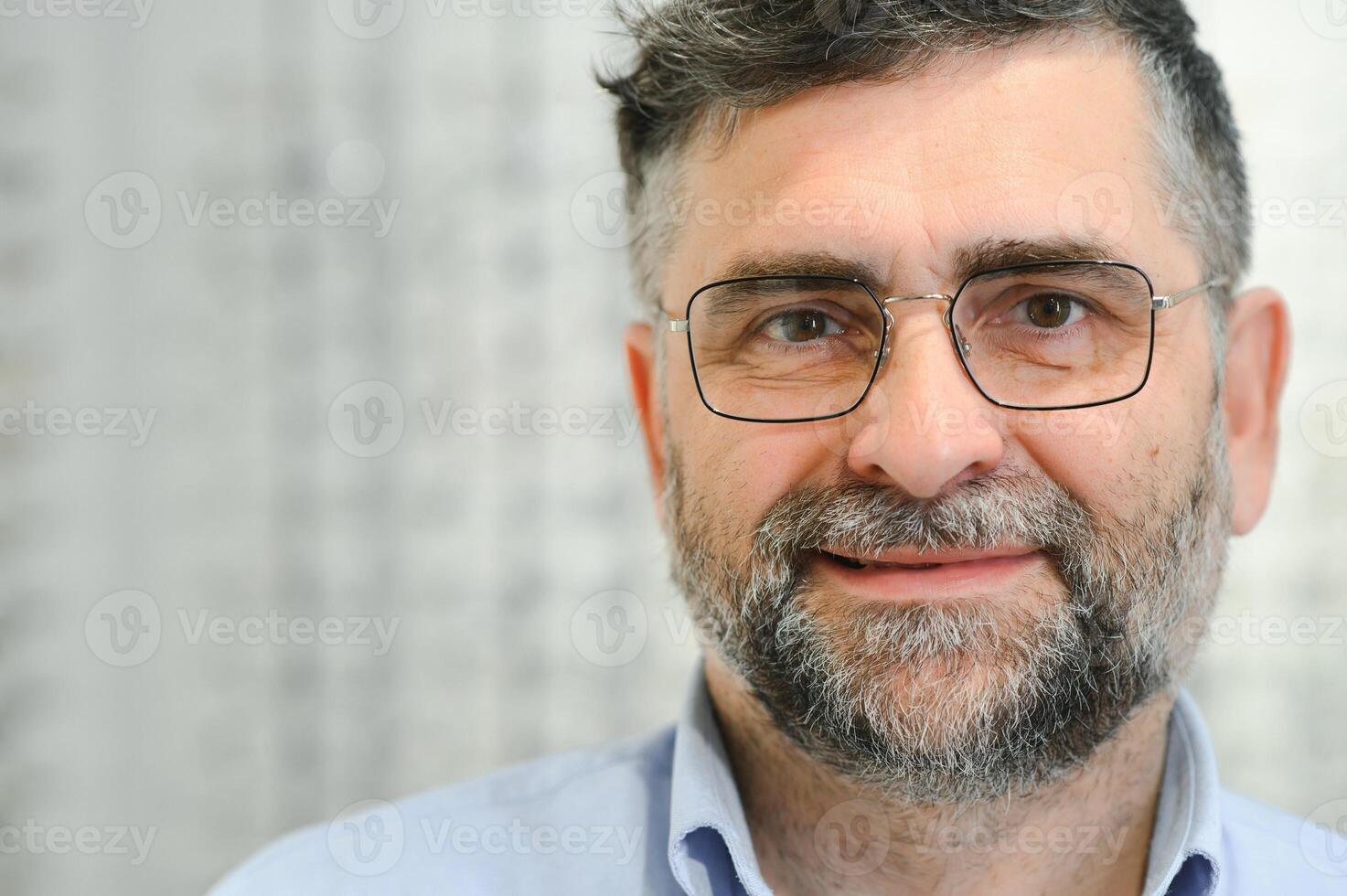 Senior man choosing glasses in optical store, try on eyeglass frames to decide on the perfect one photo