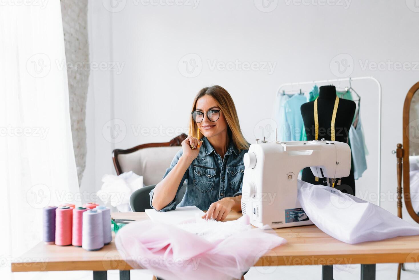 trabajando en nuevo recopilación. nuevo orden. hembra Moda diseñador trabajos en el nuevo ropa en el taller foto