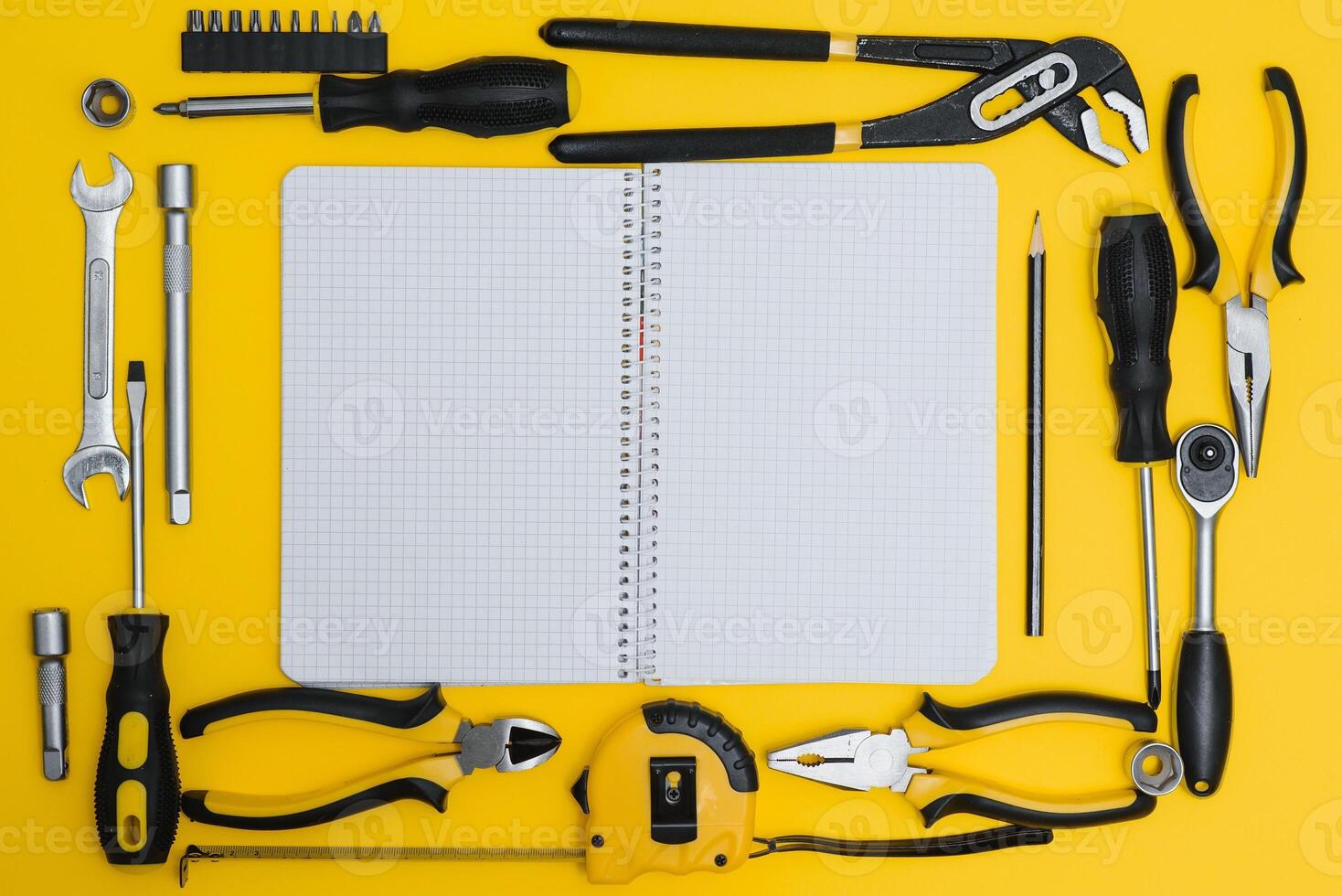 Yellow and black handy tools pilers and screwdriver isolated on yellow background. photo