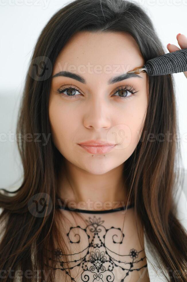 eyebrow master holding an ink gun in his hand photo