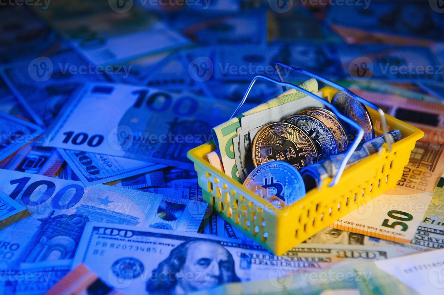 Close up heap of golden bitcoin physical coins on top of Euro, dollar banknotes background, high angle view, selective focus photo