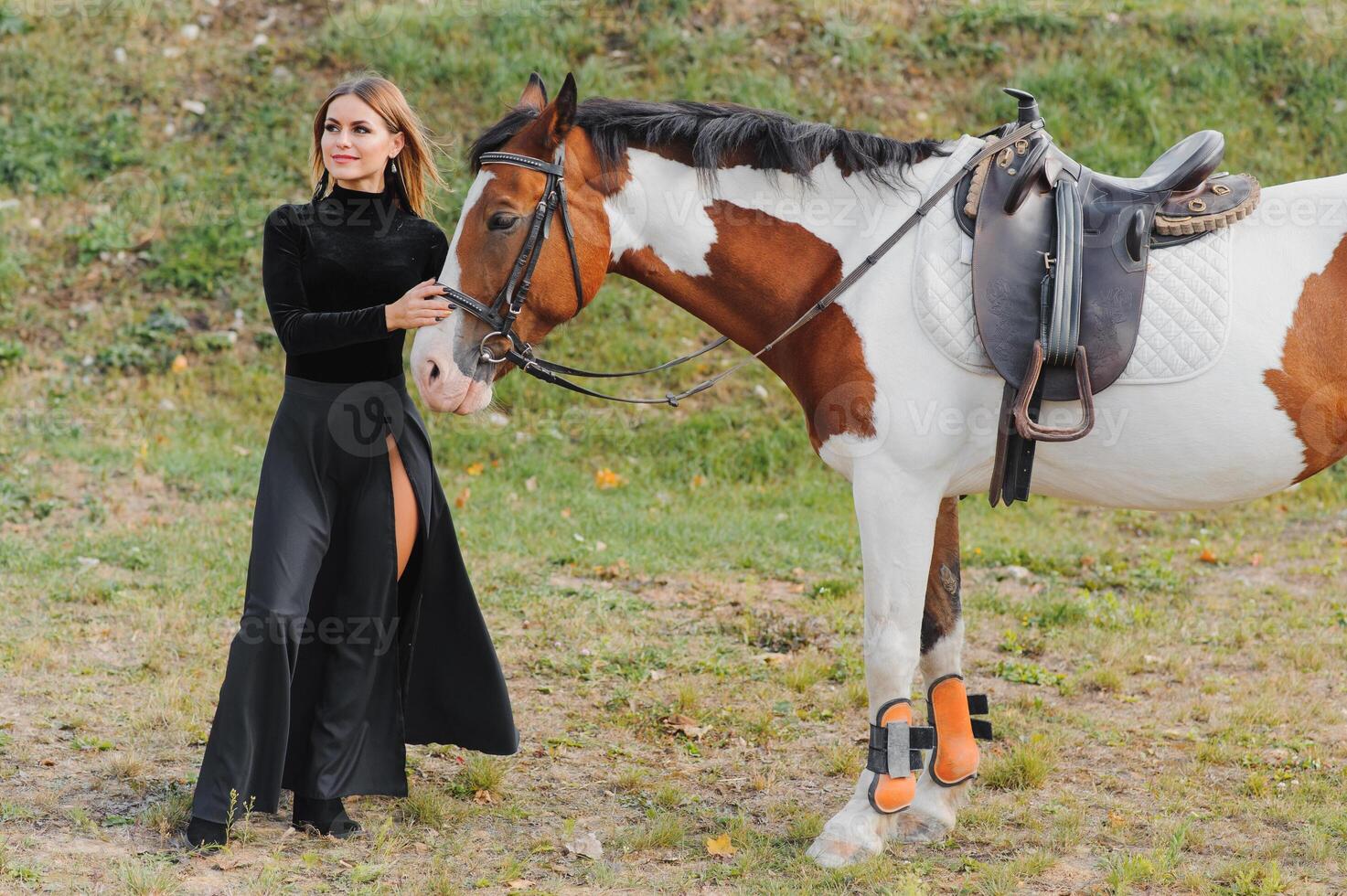 contento de moda joven mujer posando con un caballo en el playa foto