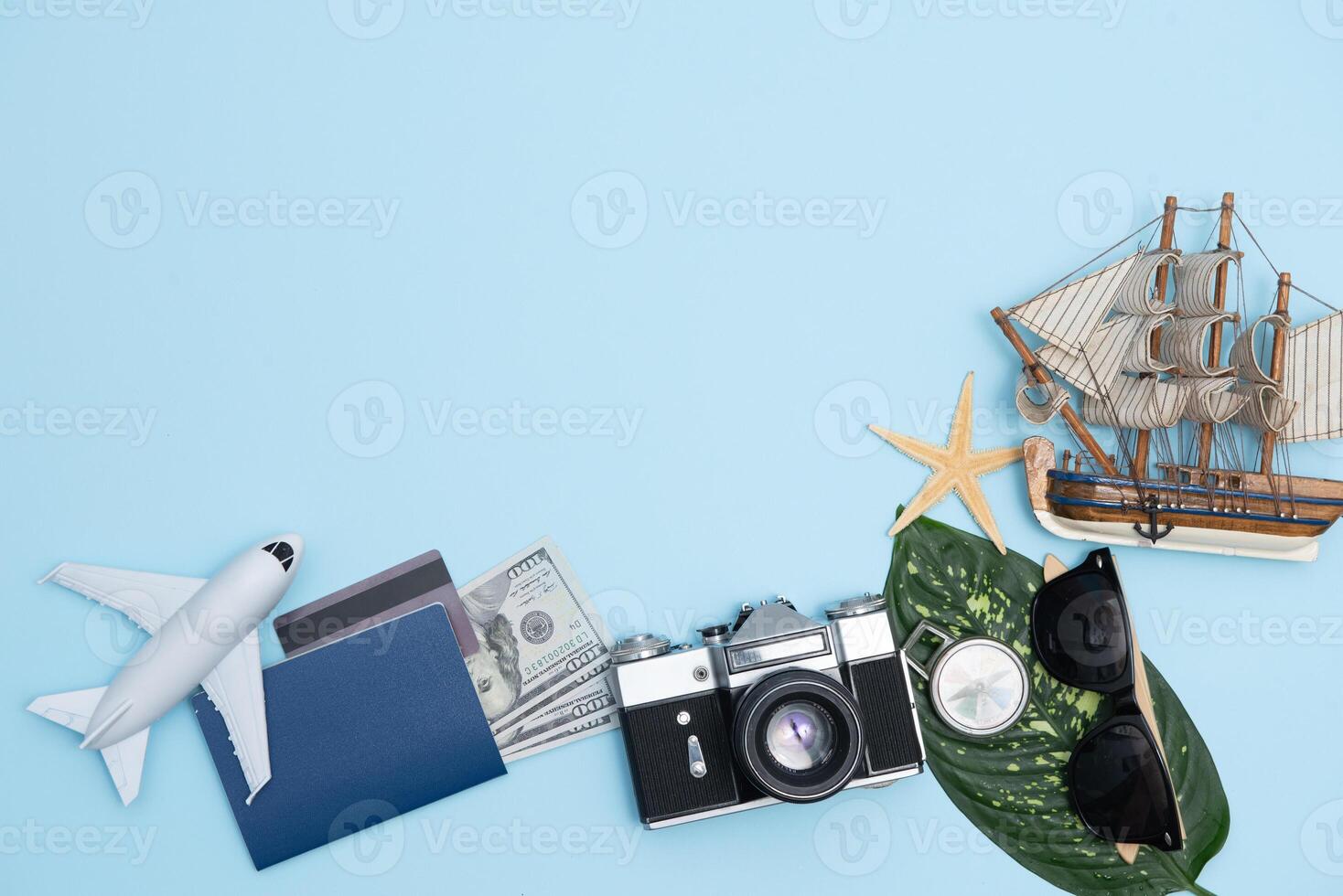 top view travel concept with retro camera films, smartphone, map, passport, compass and Outfit of traveler on blue background with copy space, Tourist essentials, vintage tone effect photo