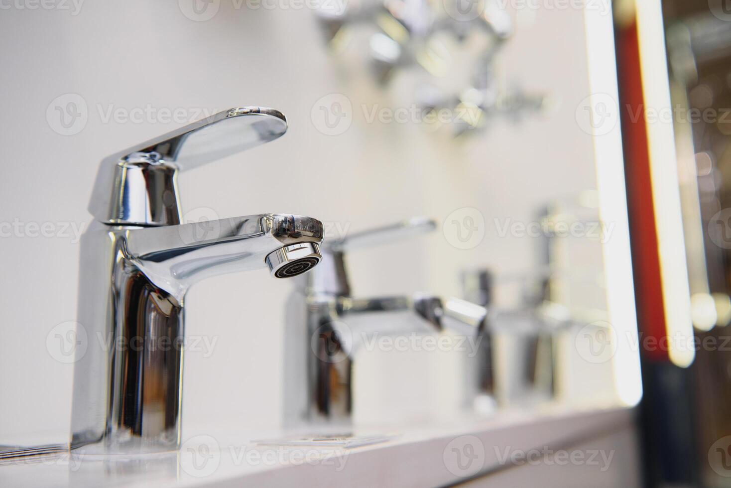 showcase in the store with faucets for the kitchen and bathroom photo