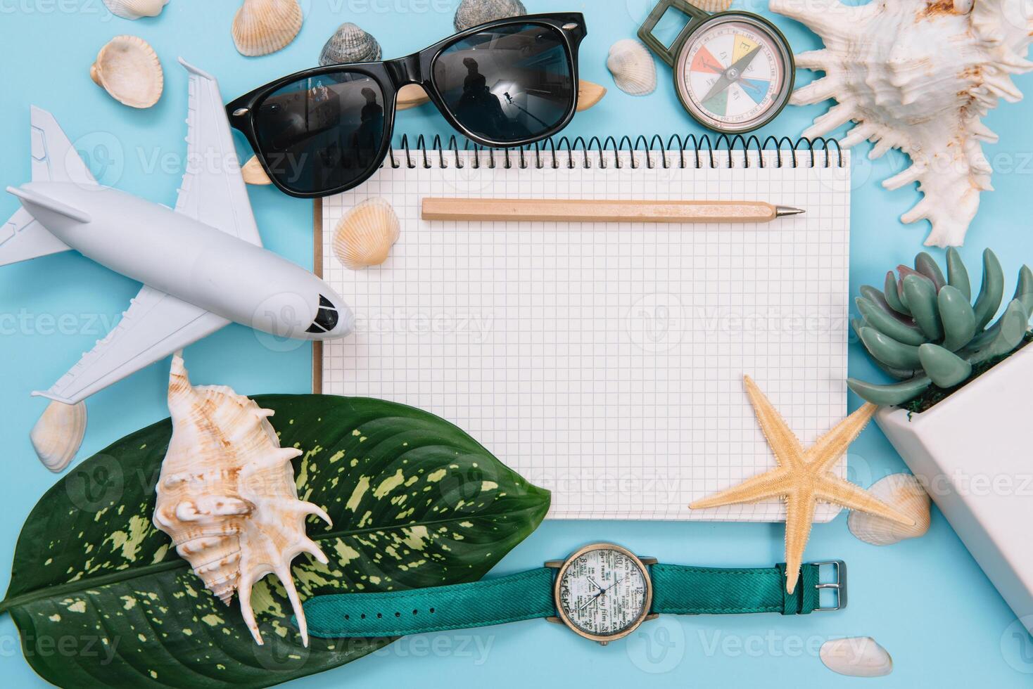 Preparation for Traveling concept, watch, airplane, money, passport, pencils, book, Photo frame, eyeglass on blue background with copy space.