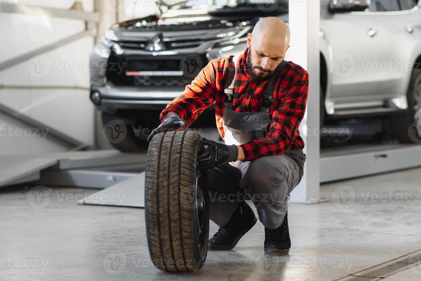 Mechanic holding a tire tire at the repair garage. replacement of winter and summer tires. photo