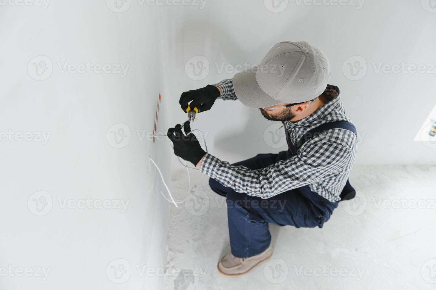 profesional electricista trabajando en un hogar eléctrico sistema, él es instalando un pared enchufe foto