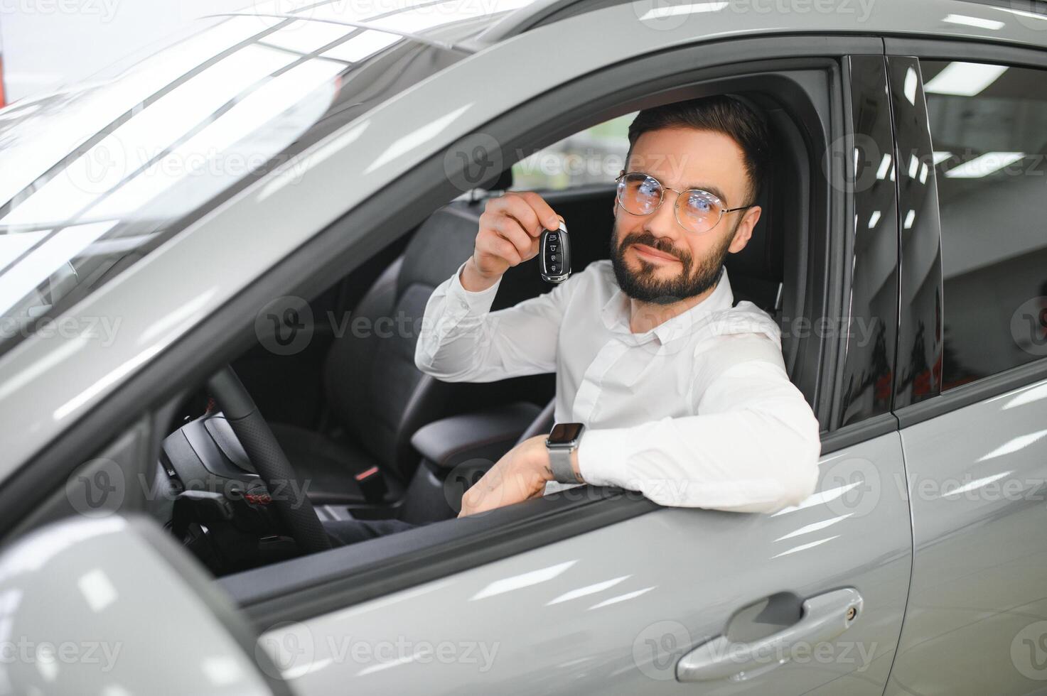 Happy caucasian man in formal wear getting inside luxury modern car for testing interior before purchase. Concept of dealership, selling and purchase photo