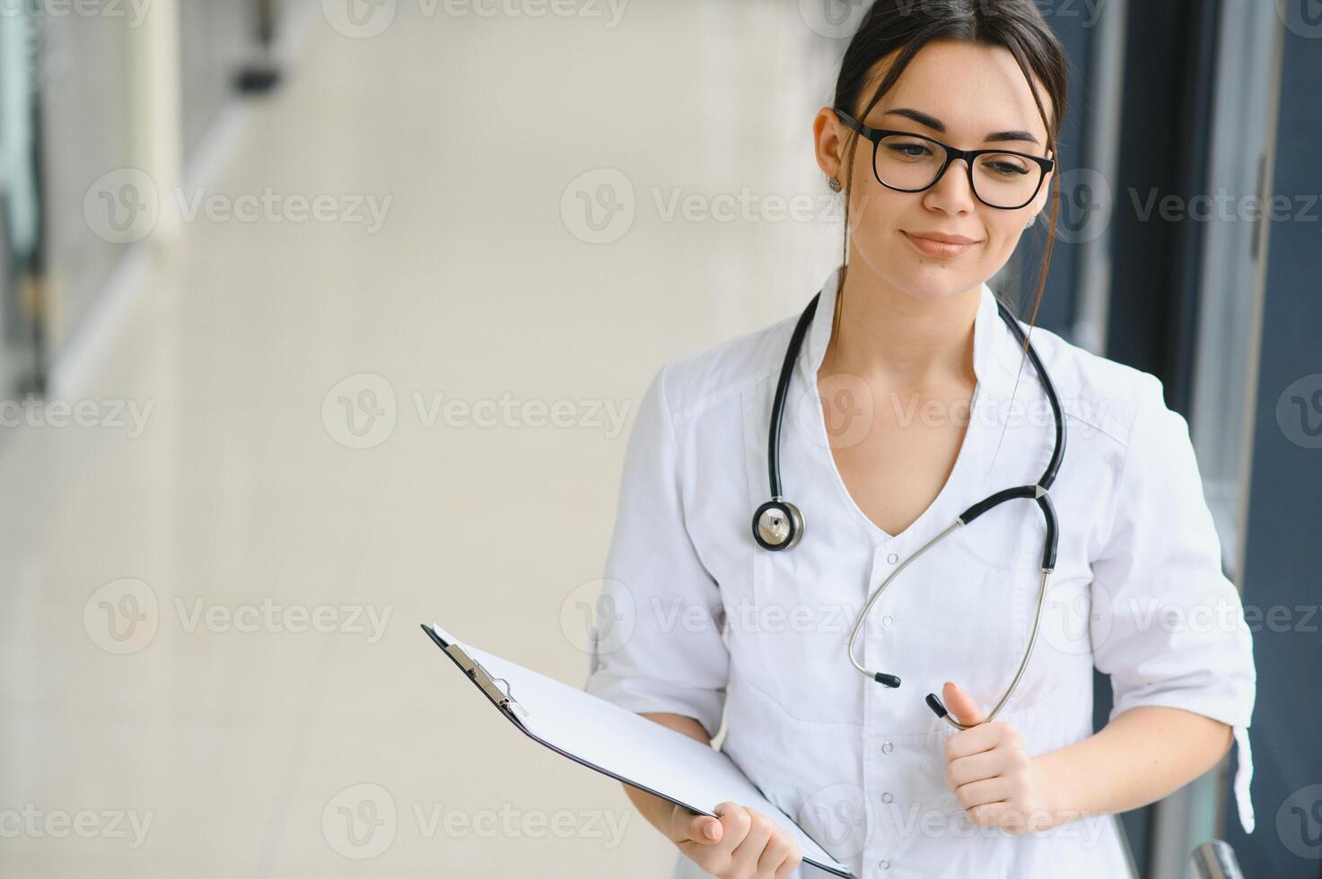 Happy young female doctor wear uniform, white medical coat, stethoscope. Portrait of beautiful female doctor, therapist, nurse. photo