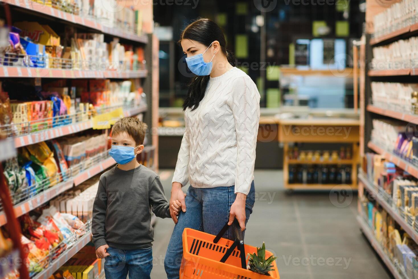 joven mujer y su niño vistiendo protector cara mascaras tienda un comida a un supermercado durante el coronavirus epidemia o gripe brote. foto