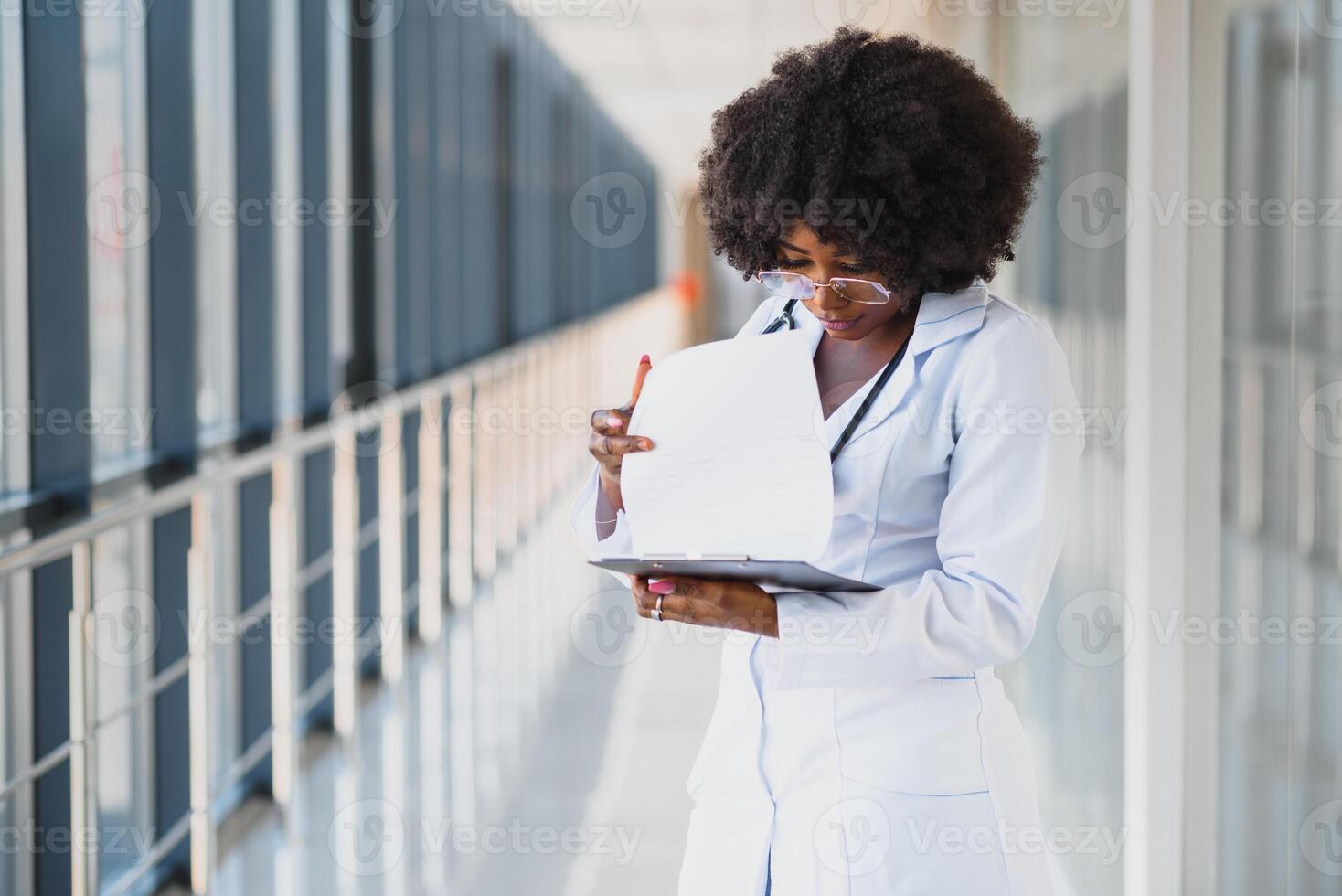 healthcare and medical concept - african doctor holding syringe with injection photo