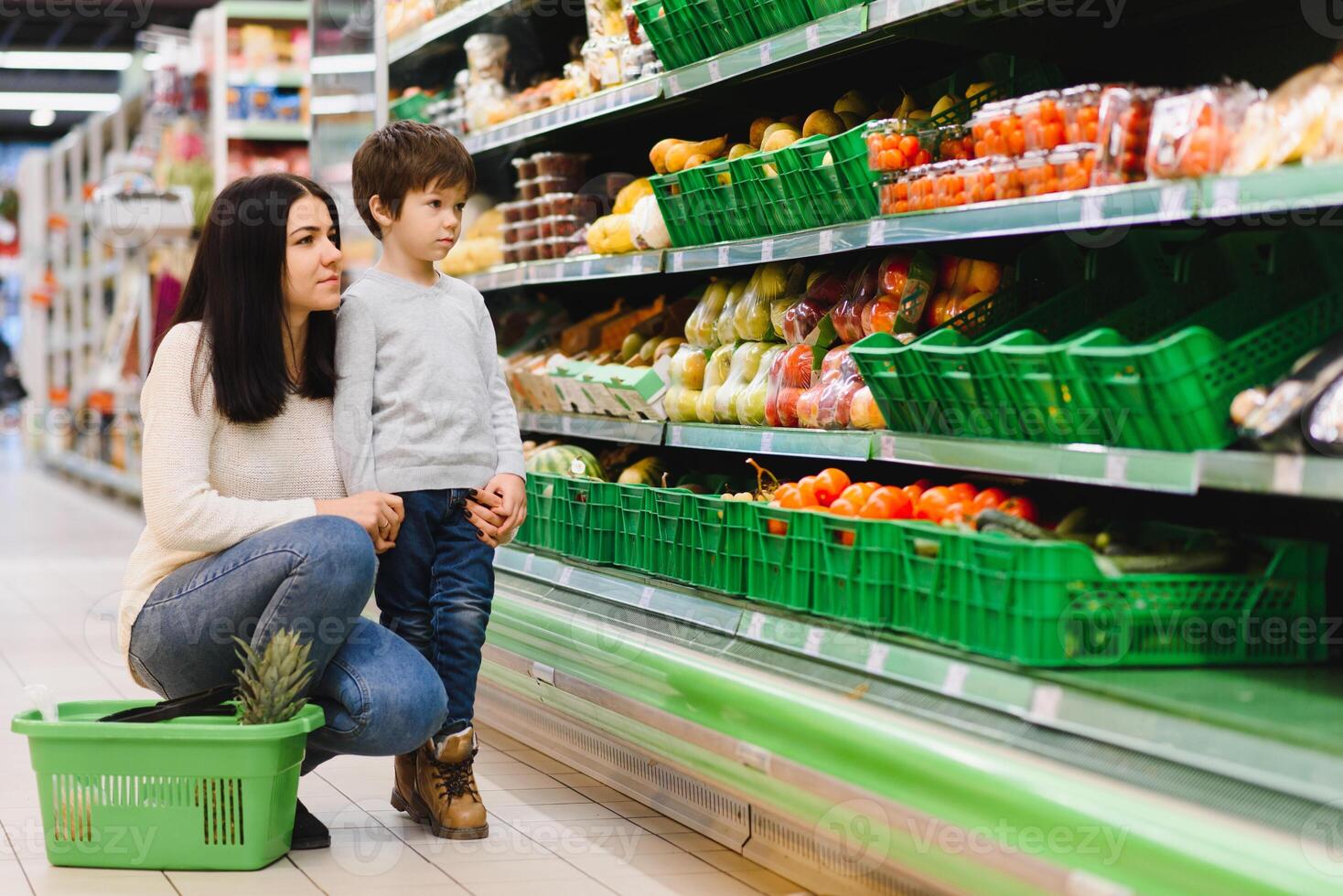 joven madre con su pequeño bebé chico a el supermercado. sano comiendo concepto foto