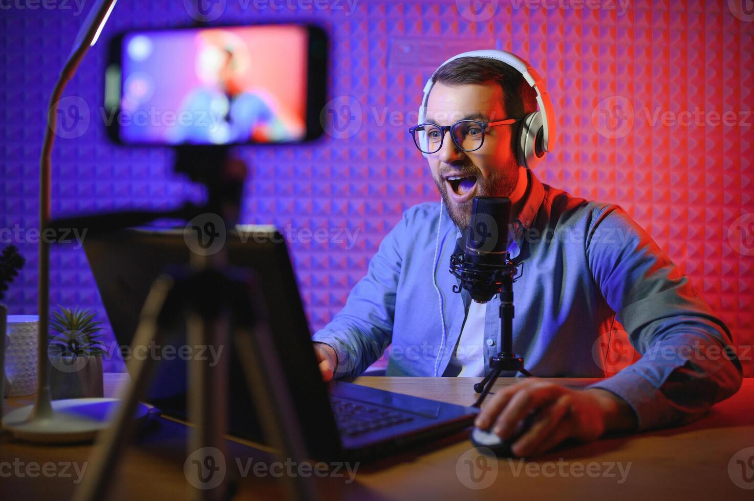 A video blogger records content in his studio. The host of the video blog is a young man who is very enthusiastic about telling his subscribers a story. photo