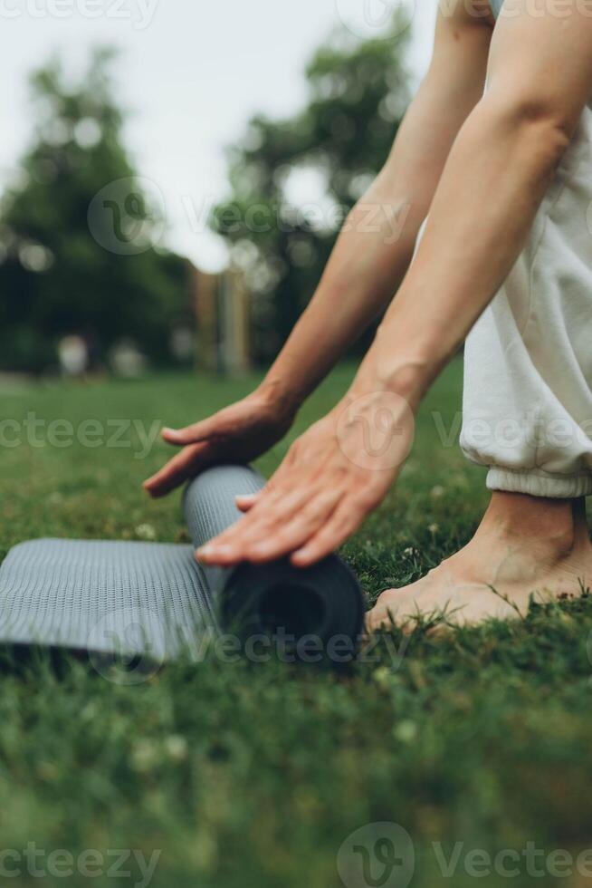 girl laying out a yoga mat in the park photo