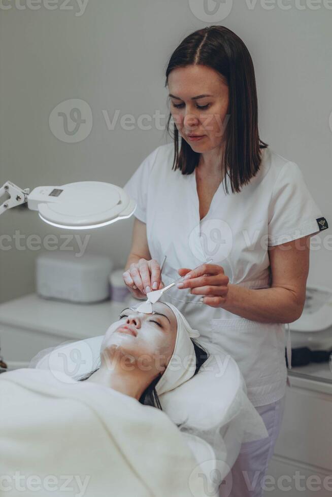 Cosmetologist esthetician performs skin treatment and rejuvenation photo