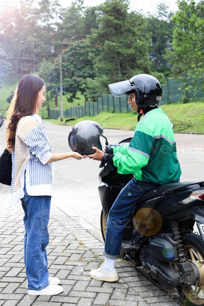 Driver Giving Helmet to Passenger photo