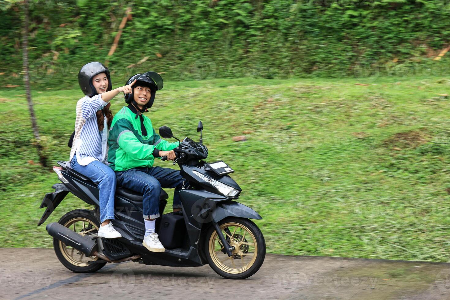 Asian Online Taxi Motorcycle Passenger Pointing a Place photo