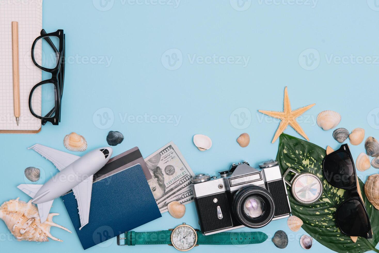 top view travel concept with retro camera films, smartphone, map, passport, compass and Outfit of traveler on blue background with copy space, Tourist essentials, vintage tone effect photo