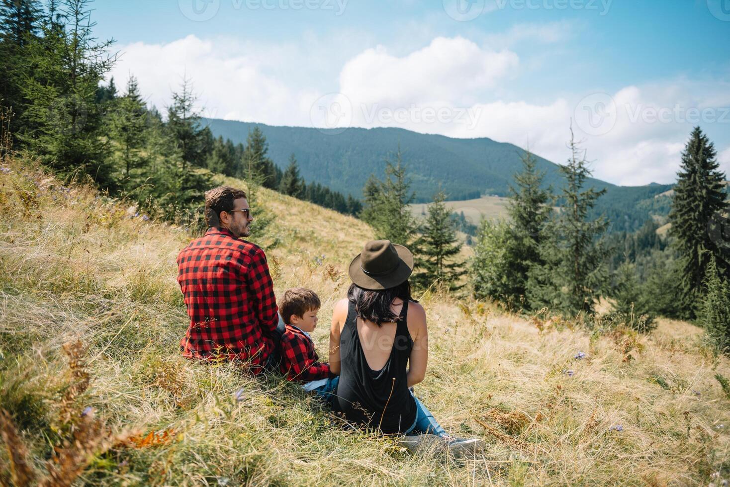 Young family with child resting on a mountain photo