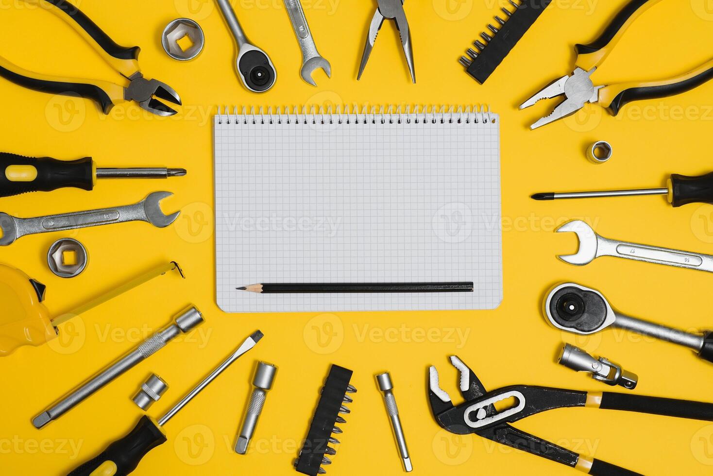 Tools top view on yellow background. Plier, open wrenches, screwdrivers and staple gun flat lay with copy space photo