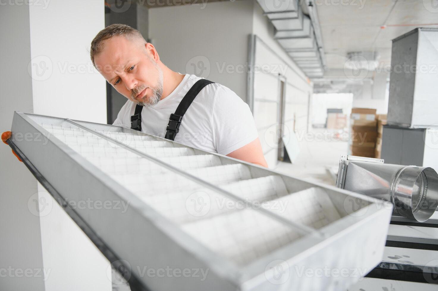 Worker holding air filter for installing in the office ventilation system. Purity of the air concept. photo
