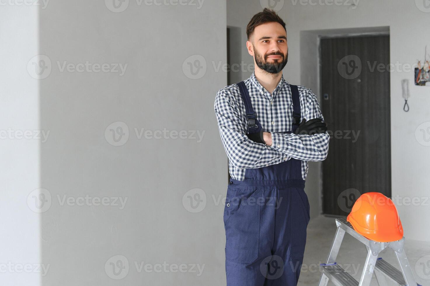 smiling repairman standing near stepladder and looking at camera photo