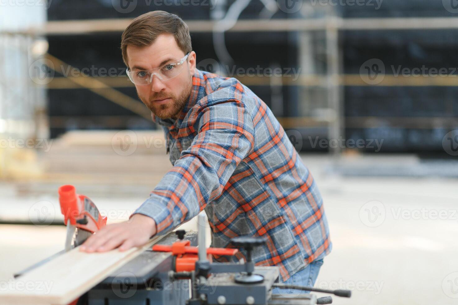 Skilled cabinet maker cutting wood board with electric circular saw at woodworking sawmill. Professional cabinet maker use circular saw at sawmill factory. Wooden furniture production. Joinery photo