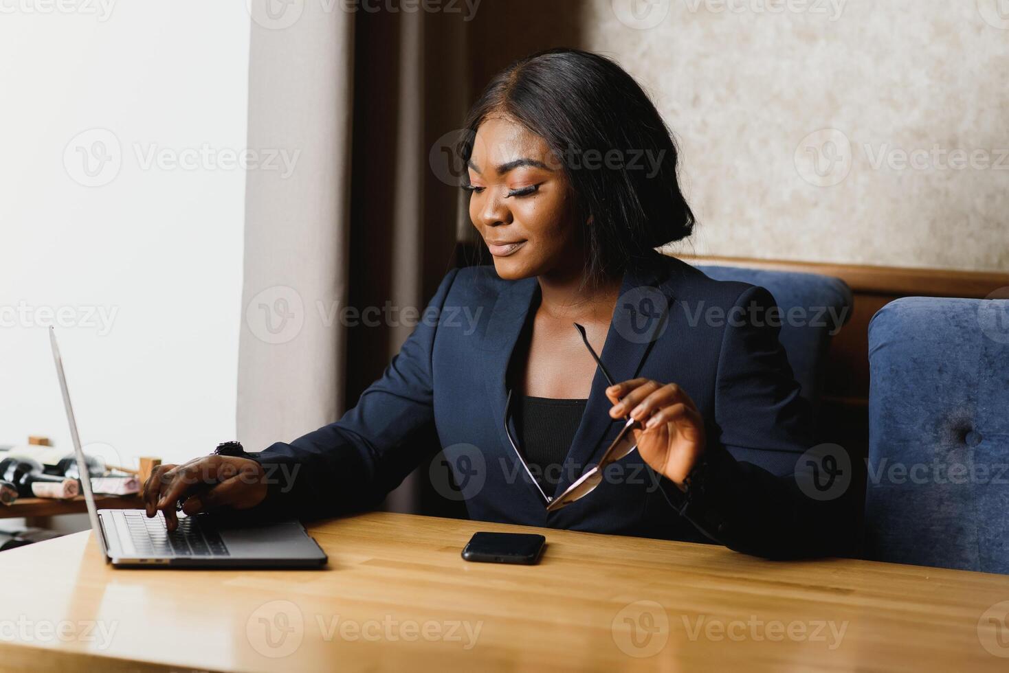 Hard work ensures success. Concentrated young African women working on laptop while sitting at working place photo