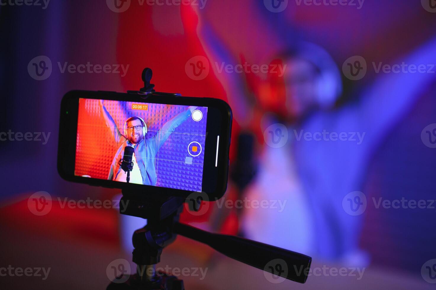 A video blogger records content in his studio. The backstage photo was taken from behind one of the participants in the shooting, at the beginning of the shooting when the blogger is preparing.