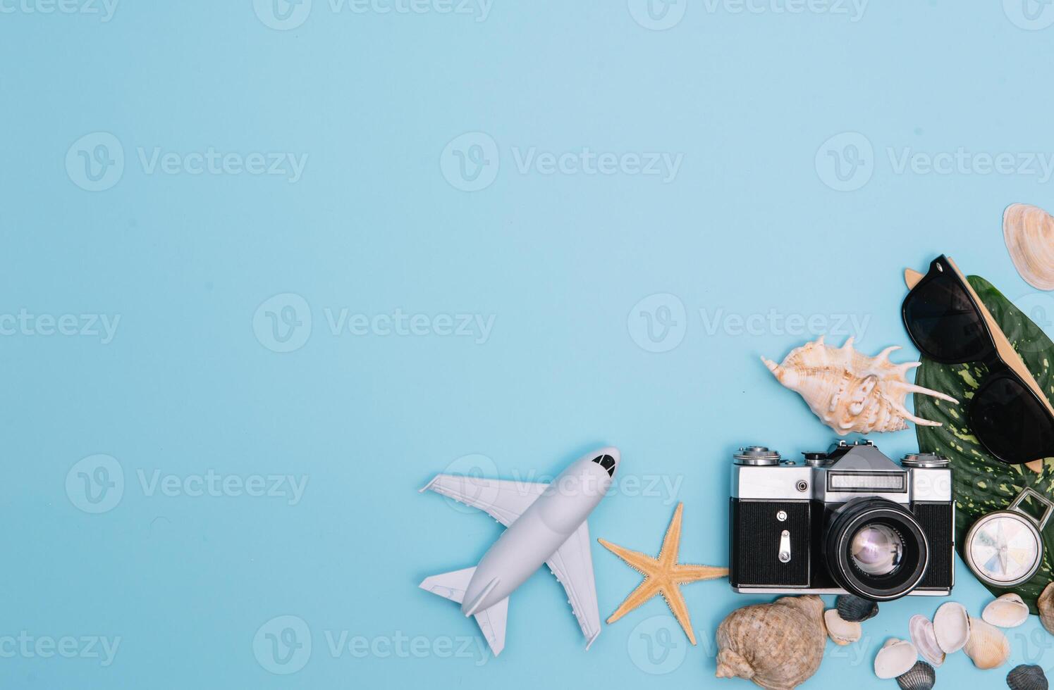 top view travel concept with retro camera films, smartphone, map, passport, compass and Outfit of traveler on blue background with copy space, Tourist essentials, vintage tone effect photo