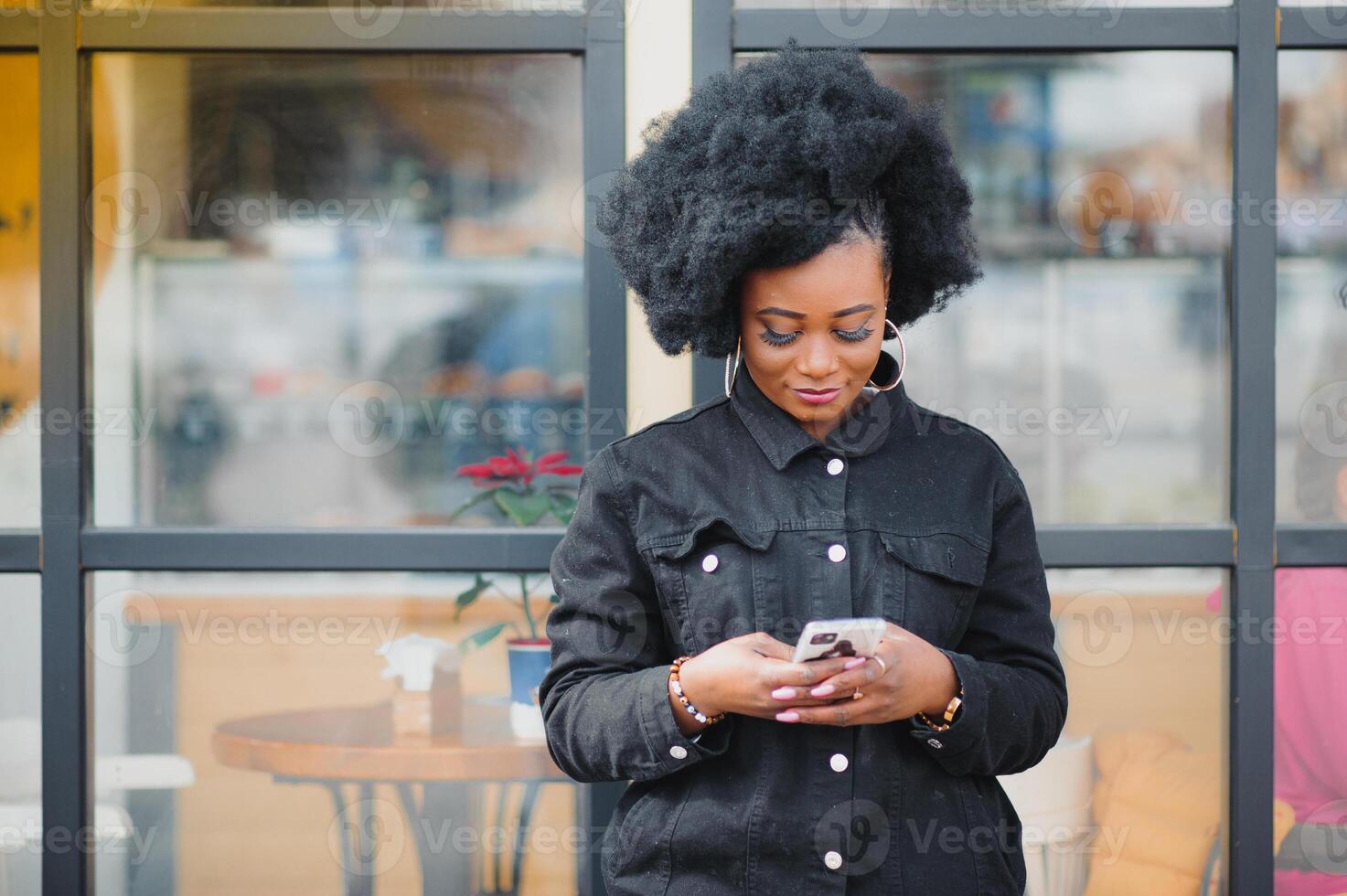 Outdoor close up portrait of young cute happy smiling african american woman with afro hairstyle. photo