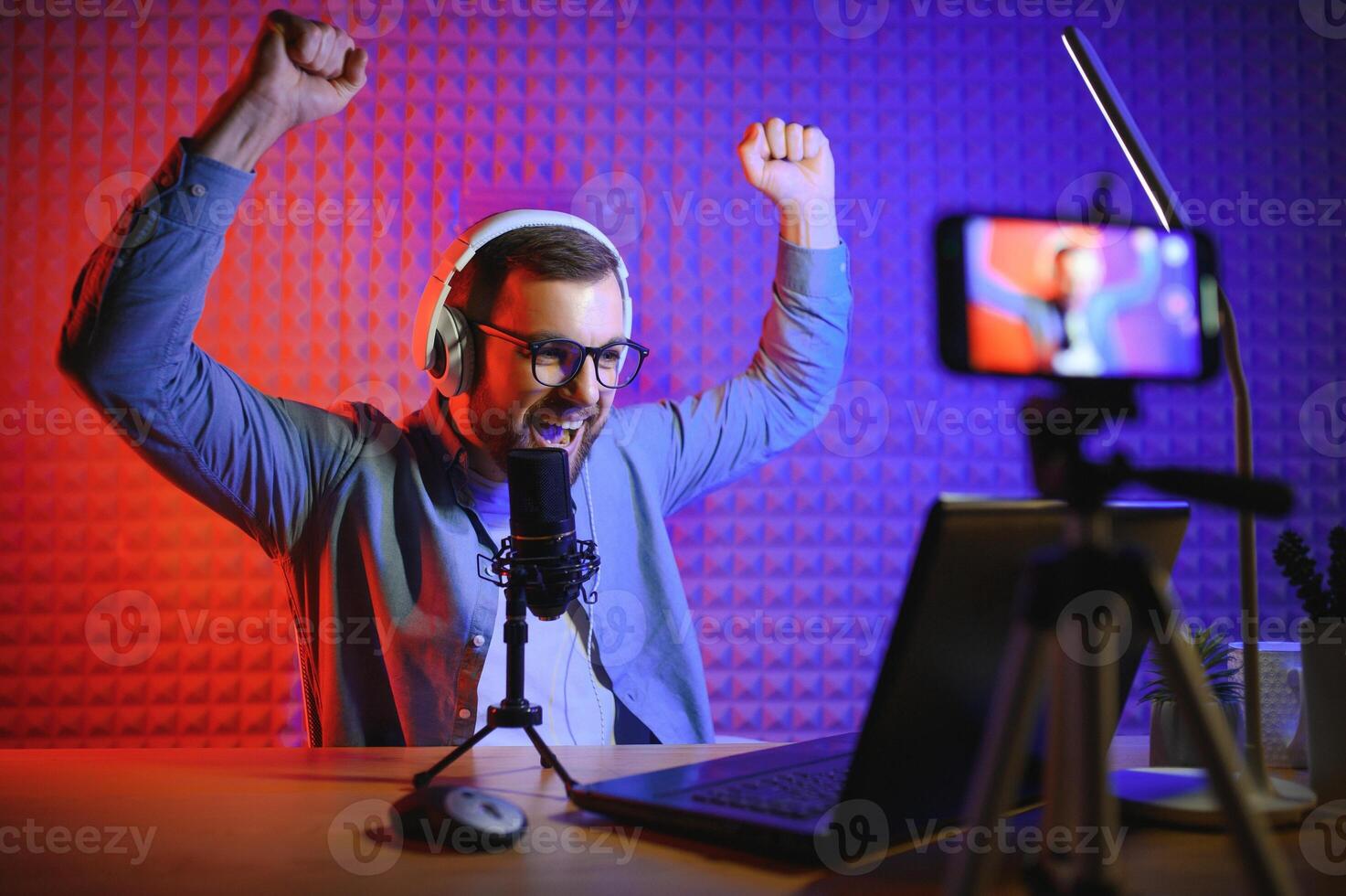 A video blogger records content in his studio. The host of the video blog is a young man who is very enthusiastic about telling his subscribers a story. photo