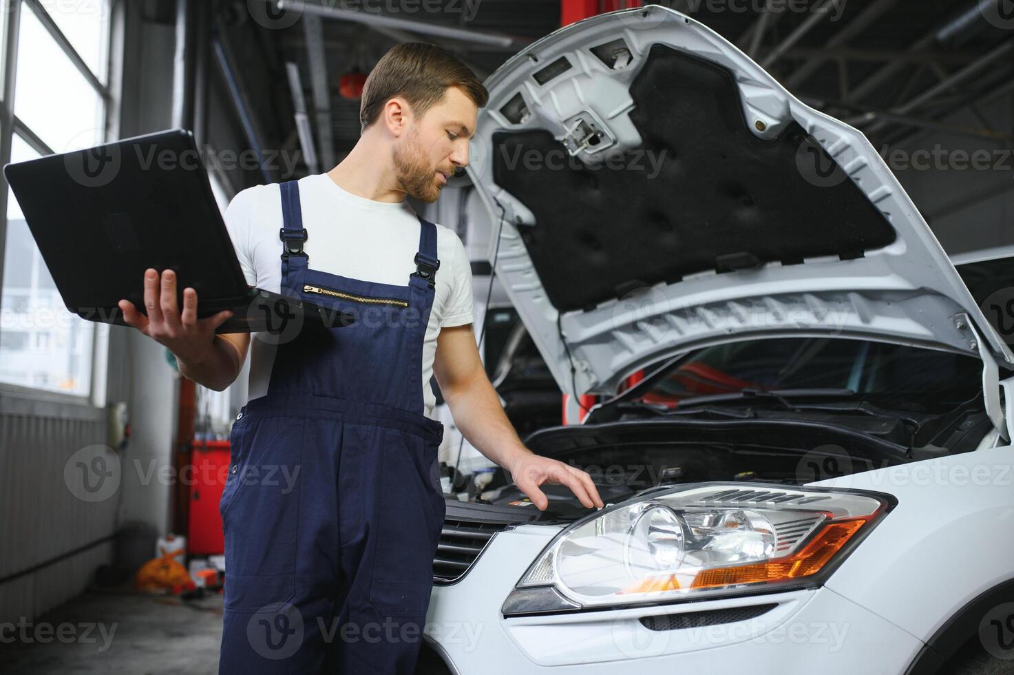 Auto service, repair, maintenance concept. mechanic checks the car, making diagnostics with laptop at the service station. Service maintenance of industrial to engine repair. photo