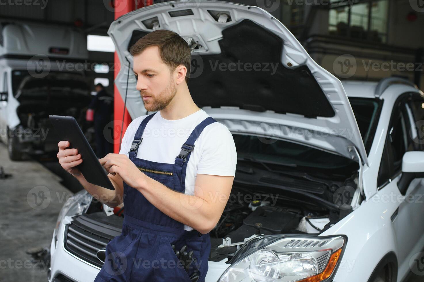 Automobile computer diagnosis. Car mechanic repairer looks for engine failure on diagnostics equipment in vehicle service workshop photo