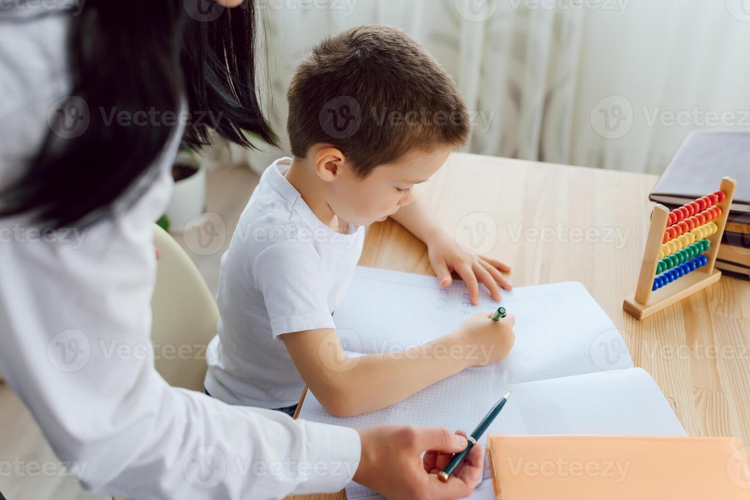 Tutor with pupil. Little boy studying. Private lesson. The concept of private lessons and homework. photo