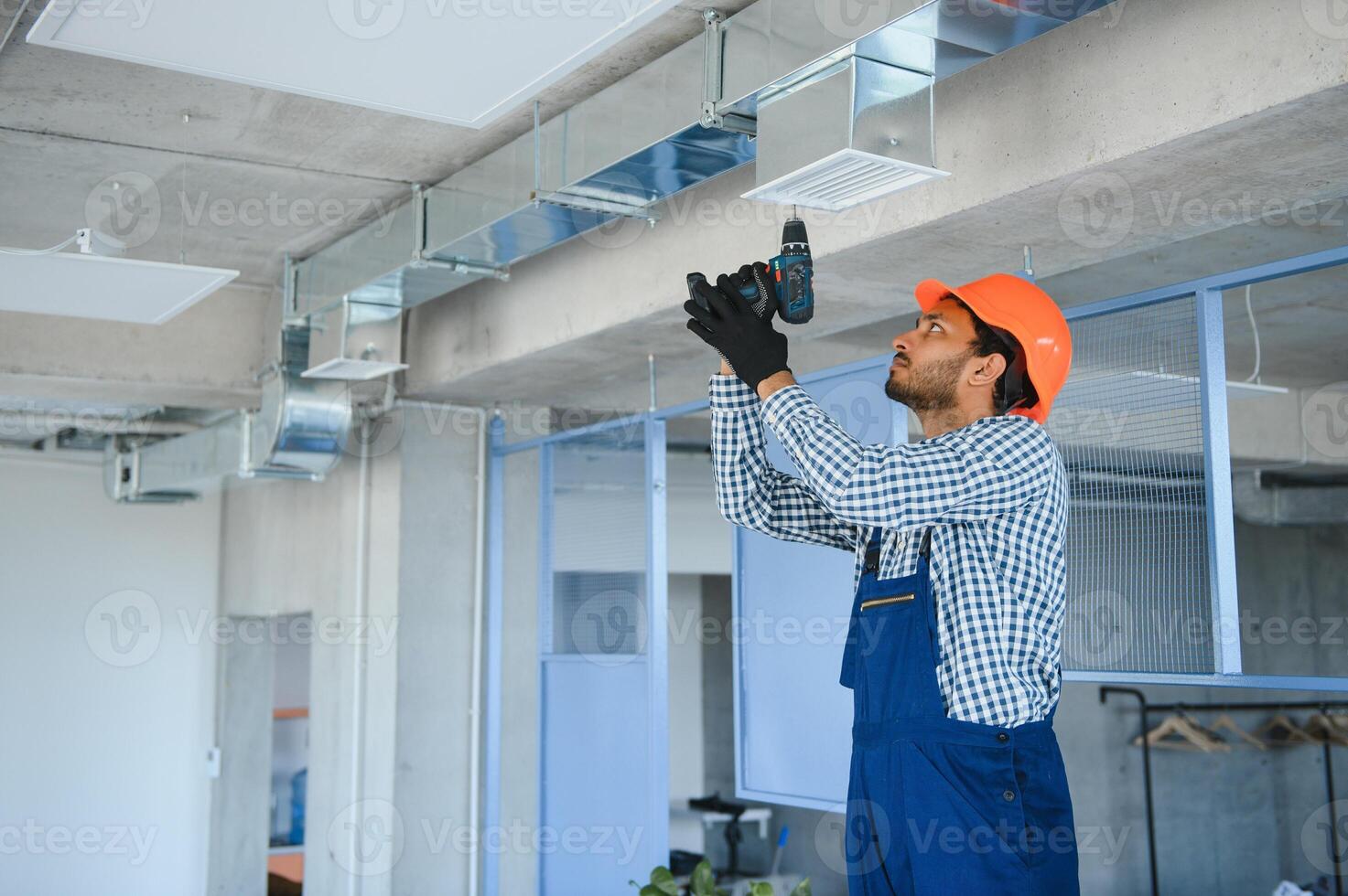 hvac services - indian worker install ducted pipe system for ventilation and air conditioning in house photo