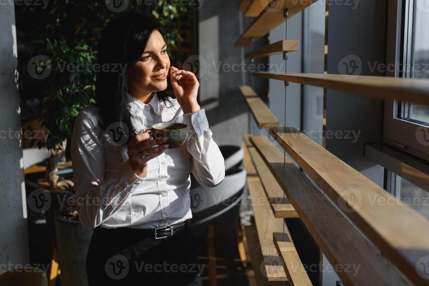 alegre atractivo mujer de negocios Bebiendo té en su oficina foto