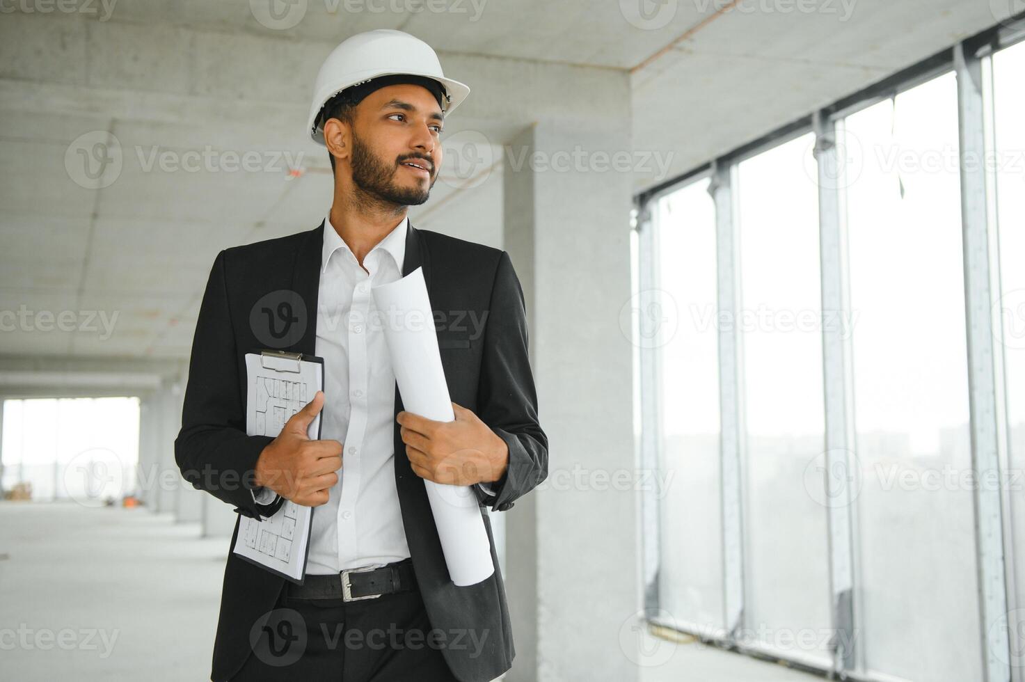 Asian engineer handsome man or architect with white safety helmet in construction site. Standing at modern building construction. Worker asian man working project building photo