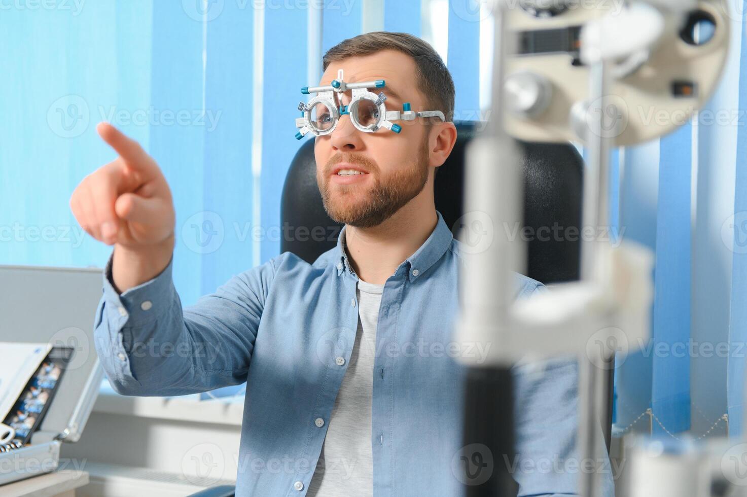 Handsome young man is checking the eye vision in modern ophthalmology clinic. Patient in ophthalmology clinic photo